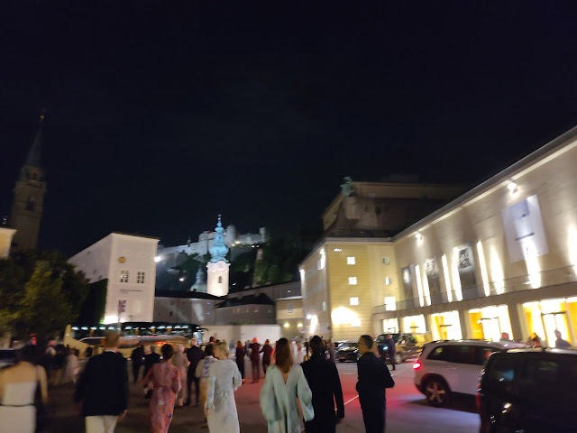 theatre-goers leaving the Haus für Mozart with Festung Hohensalzburg in the background.